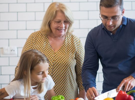 A family happily preparing vegetables together in a modern kitchen.