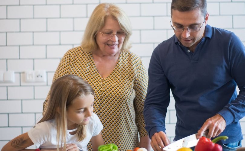 A family happily preparing vegetables together in a modern kitchen.